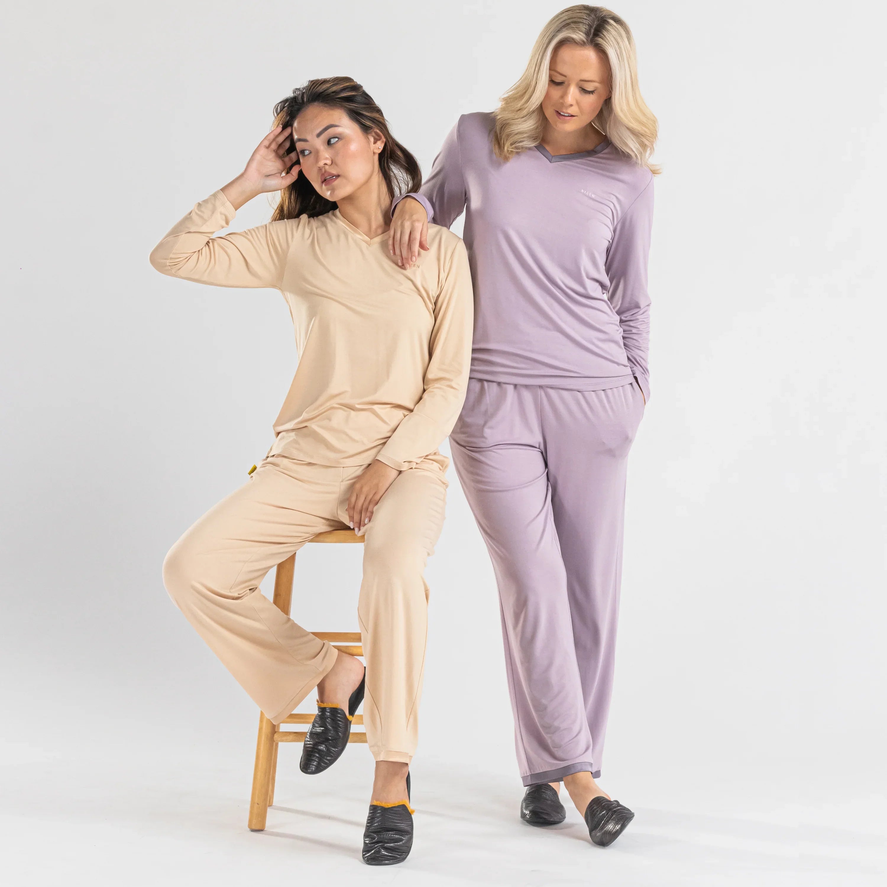 Two women modeling long sleeve loungewear sets in beige and lavender on a white background.