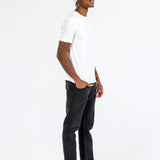 Man wearing grey cashmere hat, white t-shirt, black jeans, loafers on white background