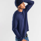 Man wearing navy cashmere hat and long sleeve shirt with jeans on white background