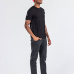 Man wearing a red cashmere hat, black t-shirt, and black jeans on white background