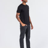 Man wearing a red cashmere hat, black t-shirt, and black jeans on white background