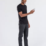 Man wearing grey music beanie with control panel, black t-shirt, using a smartphone