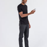 Man wearing grey music beanie with control panel, black t-shirt, using a smartphone