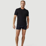 Man wearing black t-shirt and boxer briefs on plain light background