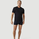 Man wearing black t-shirt and boxer briefs on plain light background