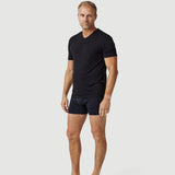 Man modeling black V-neck t-shirt and black boxer briefs on white background