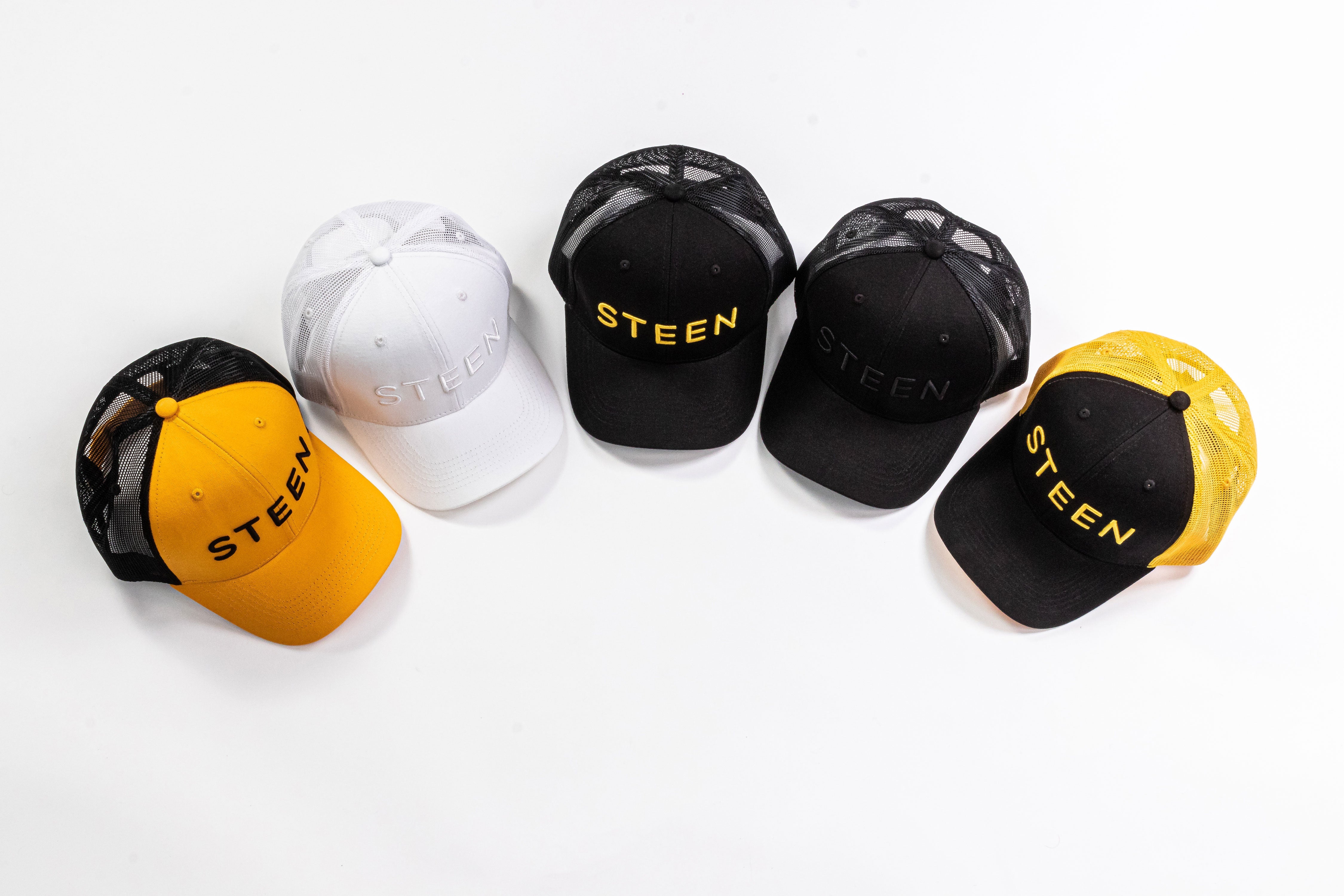 Five STEEN trucker hats in black, white, and yellow mesh on a white background