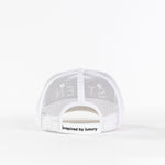 White mesh trucker hat back view with 'inspired by luxury' text on strap