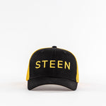 Black and yellow STEEN trucker hat with mesh back on white background