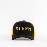Black and yellow STEEN trucker hat with mesh back on white background