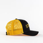 Yellow mesh trucker hat with black front panel and curved bill on white background