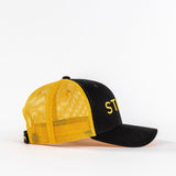 Yellow mesh trucker hat with black front panel and curved bill on white background