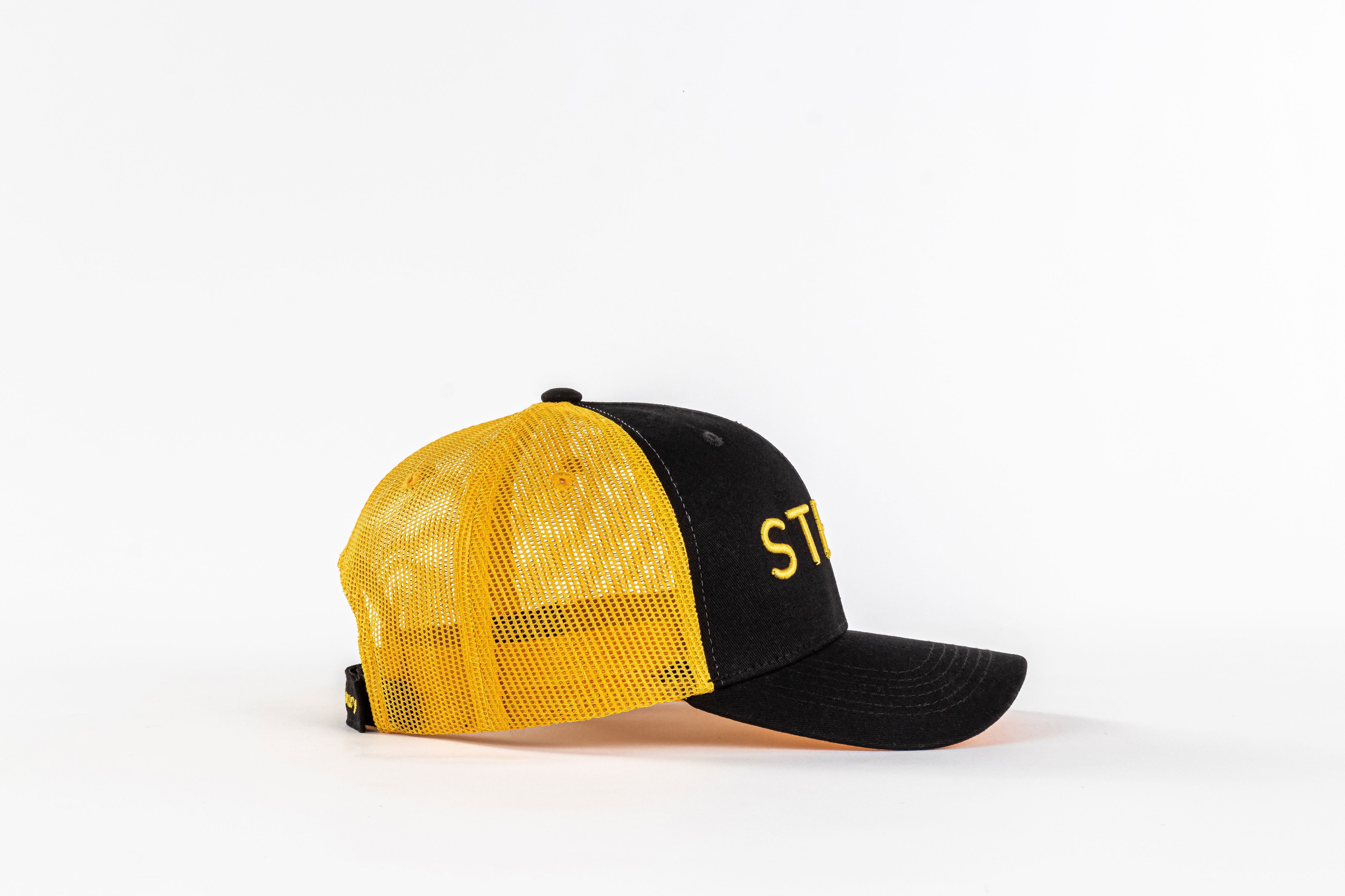Yellow mesh trucker hat with black front panel and curved bill on white background