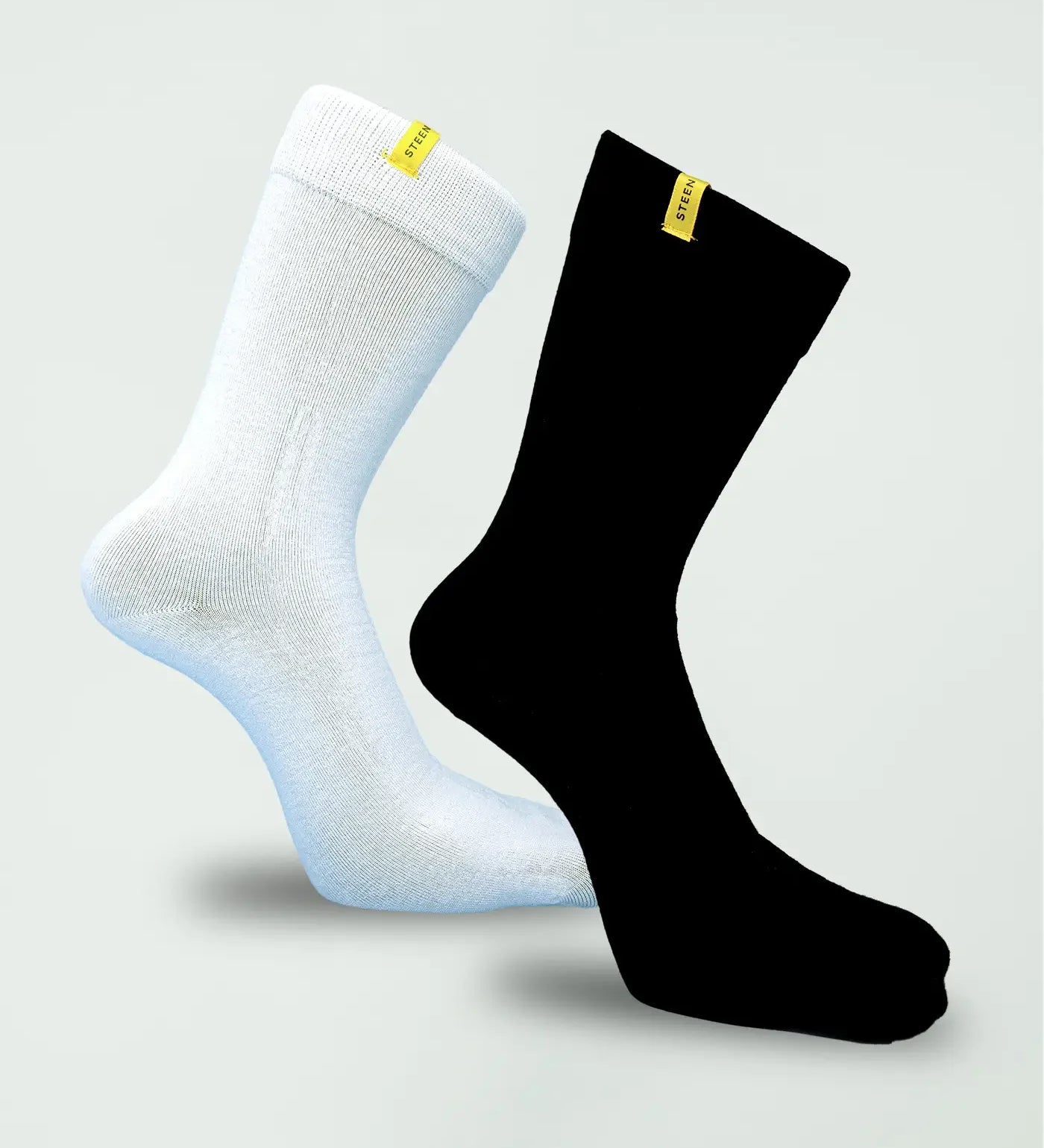 White and black bamboo socks with yellow STEEN labels on plain background