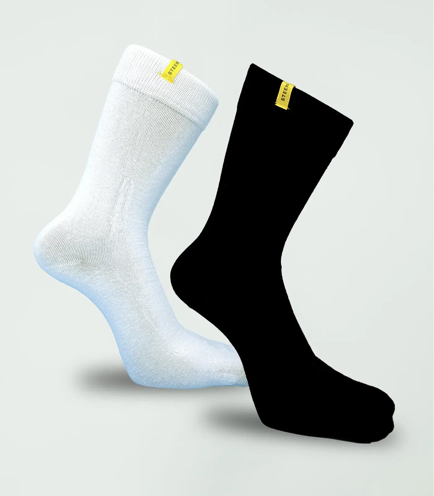 White and black bamboo socks with yellow STEEN labels on plain background