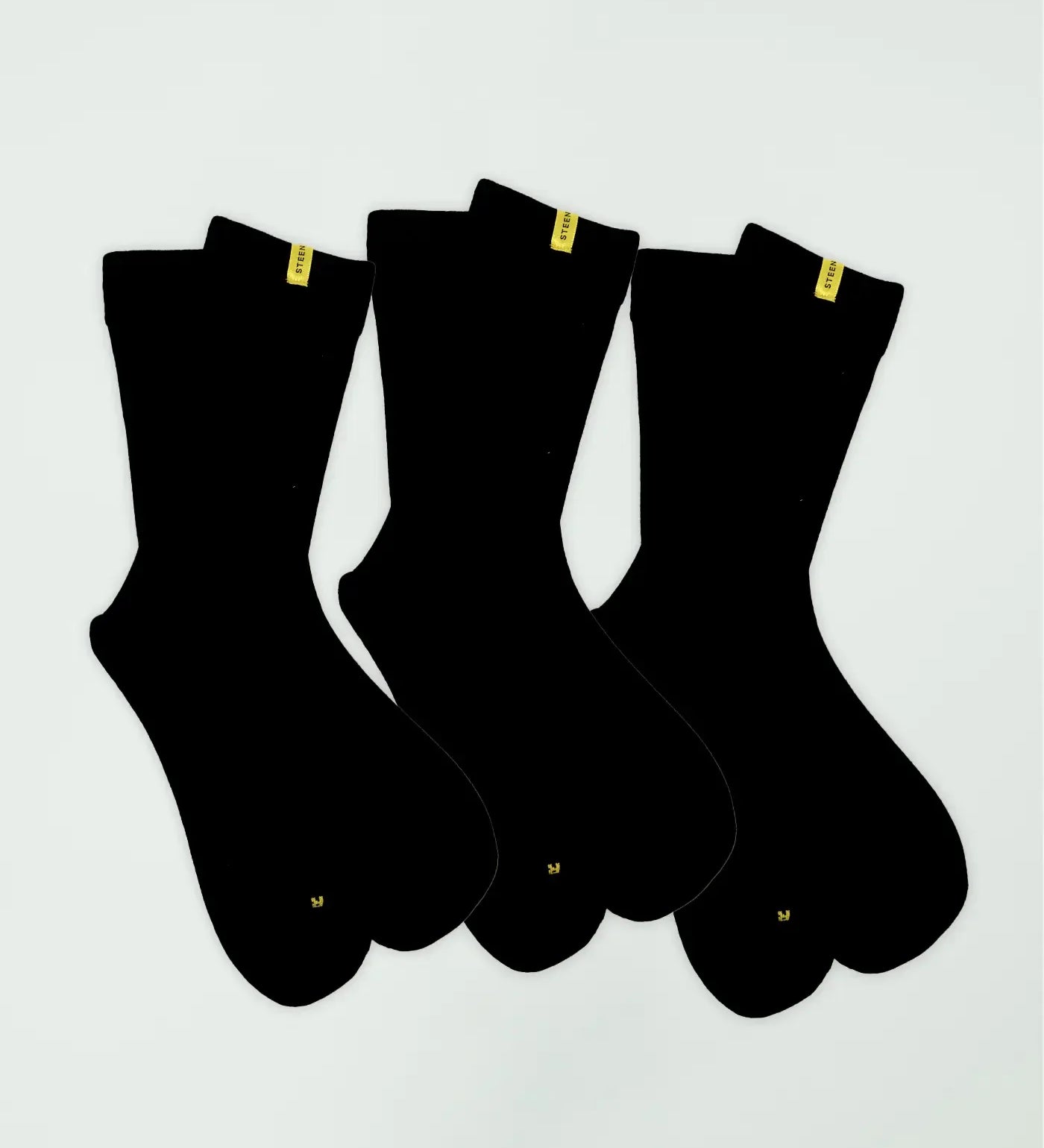 Three pairs of black bamboo socks with yellow STEEN tags on a white background