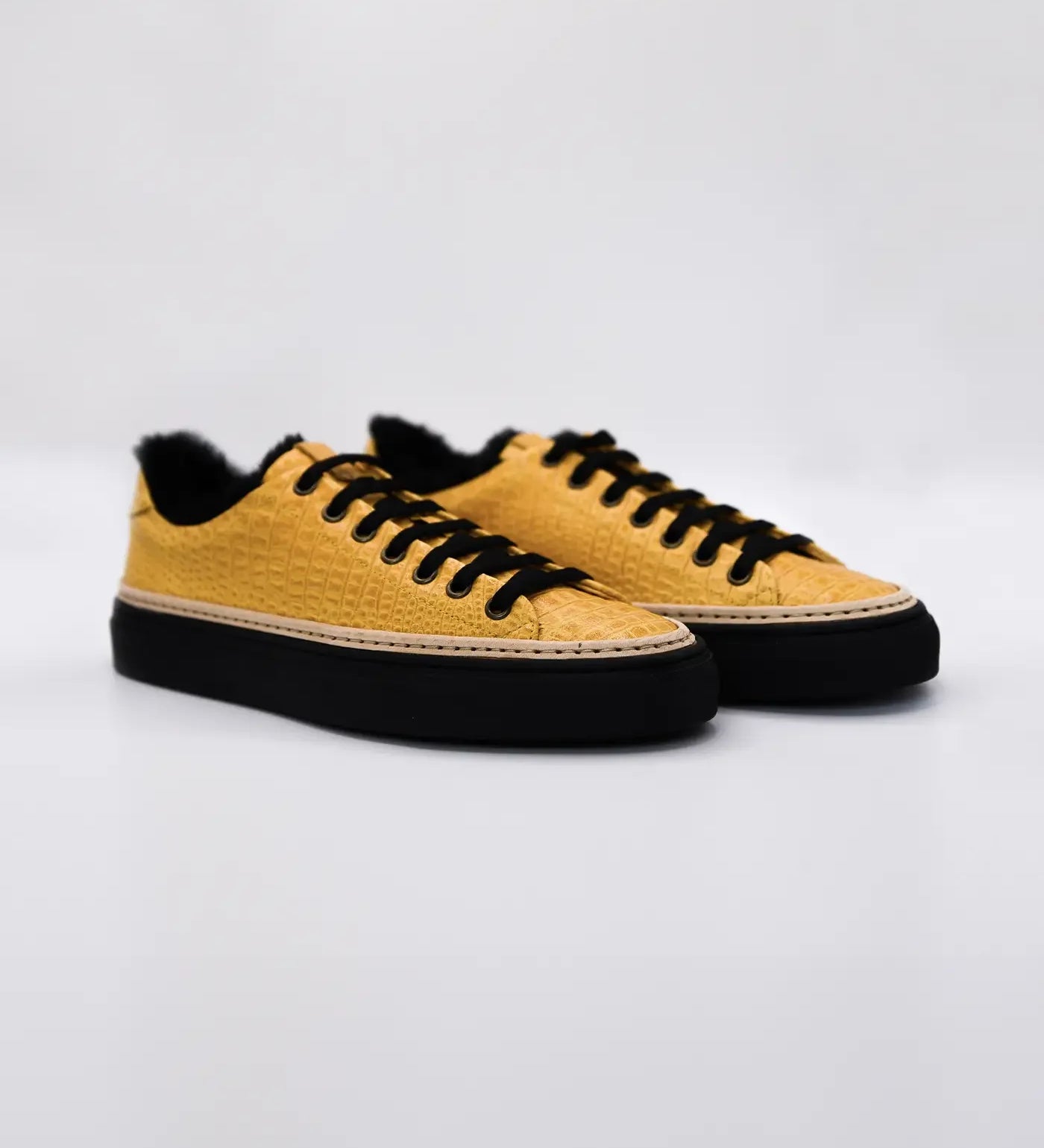 Yellow women's sneakers with black laces and soles on white background