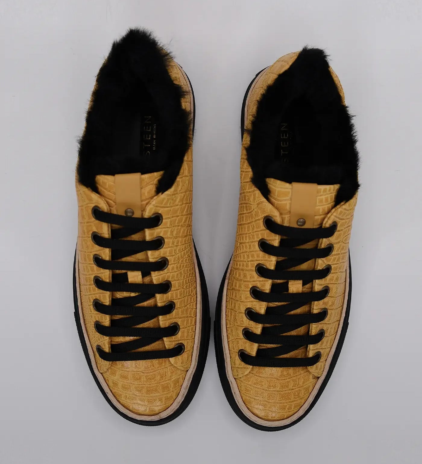 Yellow and black women's sneakers with textured pattern and black laces, top view