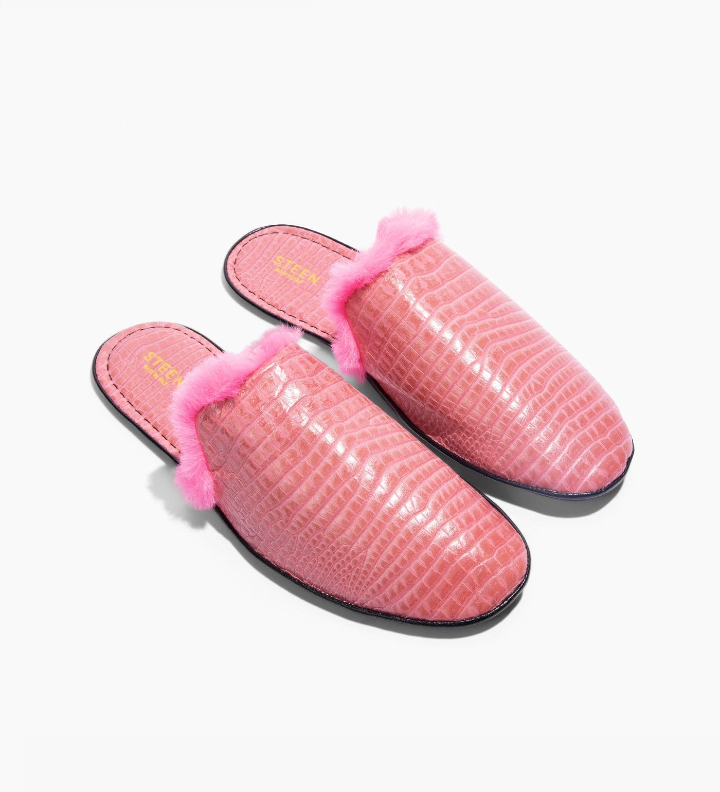 Pink women's fur slippers with crocodile pattern on a white background