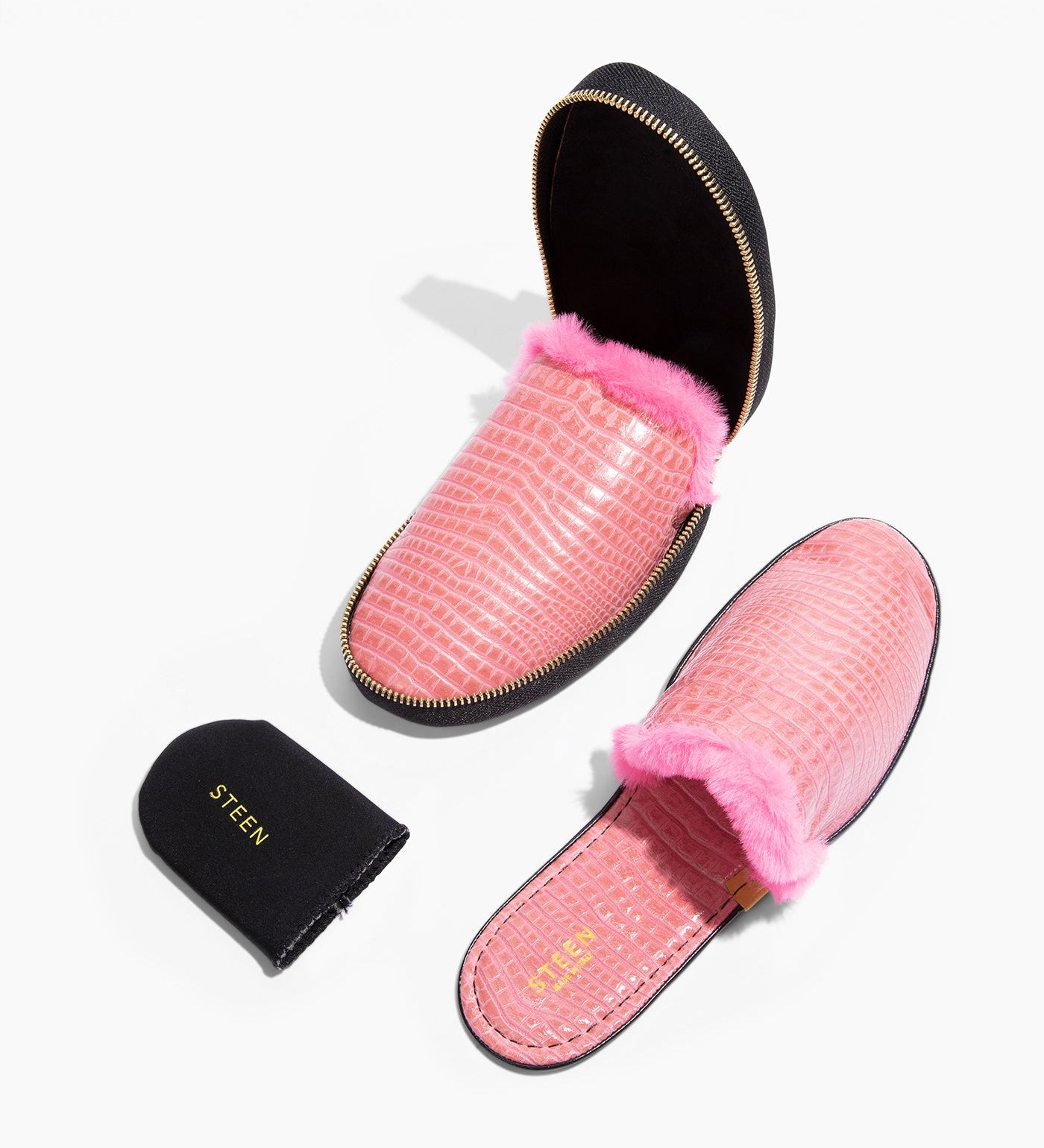 Pink women's fur slippers with crocodile texture and zipper case on white background